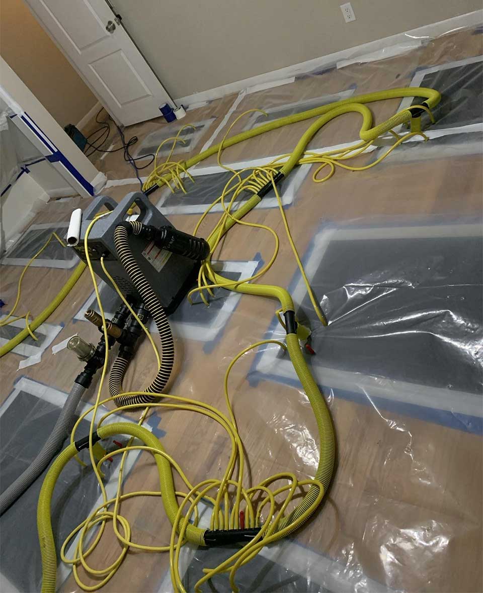 BORLakewood Floor Restoration Water damage restoration equipment with hoses and plastic sheeting